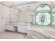A spacious bathroom with stained glass window, chandelier, tub, and vanity at 1388 Brightwaters Ne Blvd, St Petersburg, FL 33704
