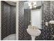 Charming half bathroom with floral wallpaper and pedestal sink at 1388 Brightwaters Ne Blvd, St Petersburg, FL 33704