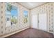 A wallpapered bedroom that offers two windows and access to the outdoor living area at 1388 Brightwaters Ne Blvd, St Petersburg, FL 33704