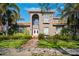 Two-story house with stucco exterior, tile roof, and lush landscaping at 1388 Brightwaters Ne Blvd, St Petersburg, FL 33704