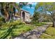 Two-story house with lush landscaping and a tree-lined street at 1388 Brightwaters Ne Blvd, St Petersburg, FL 33704