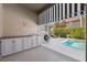 Outdoor kitchen with granite countertops and white cabinets, adjacent to pool at 1388 Brightwaters Ne Blvd, St Petersburg, FL 33704