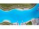 Aerial view of a large lagoon pool with surrounding landscape at 16820 Anchor Root St, Wimauma, FL 33598