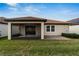 Covered patio and fenced backyard with lawn at 16820 Anchor Root St, Wimauma, FL 33598