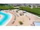 Beach volleyball court next to a lagoon and lounge chairs at 16820 Anchor Root St, Wimauma, FL 33598