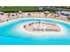 Sandy beach area surrounding a lagoon with lounge chairs at 16820 Anchor Root St, Wimauma, FL 33598