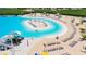 Expansive sandy beach with lounge chairs surrounding a lagoon at 16820 Anchor Root St, Wimauma, FL 33598