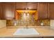 Clean kitchen with wood cabinets and a neutral backsplash at 2750 E Bay Dr # 15E, Largo, FL 33771