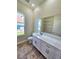 Bathroom features a single sink vanity, framed mirror, and tile flooring at 295 Woodstream Way, Spring Hill, FL 34608