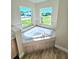 Corner bathtub with large windows in the bathroom at 295 Woodstream Way, Spring Hill, FL 34608