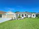 Single-story home with three-car garage and landscaped lawn at 295 Woodstream Way, Spring Hill, FL 34608