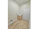 Empty laundry room featuring wood look tile floors, door to outside, and utility sink at 295 Woodstream Way, Spring Hill, FL 34608