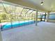 Covered patio with large in-ground pool and view to fenced backyard at 295 Woodstream Way, Spring Hill, FL 34608