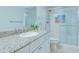 Well-lit bathroom featuring a granite vanity, glass-enclosed shower and modern fixtures at 322 Windrush Blvd # 2, Indian Rocks Beach, FL 33785