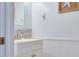 Stylish powder room with attractive vanity, decor and wainscoting at 322 Windrush Blvd # 2, Indian Rocks Beach, FL 33785