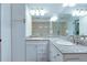 Bathroom featuring granite countertops, double sinks, and white cabinetry for ample storage at 322 Windrush Blvd # 2, Indian Rocks Beach, FL 33785
