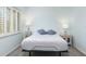 Bright bedroom featuring a comfortable bed with stylish bedside tables and window shutters at 322 Windrush Blvd # 2, Indian Rocks Beach, FL 33785