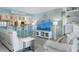Bright, coastal-style living room with comfortable seating and views into the kitchen at 322 Windrush Blvd # 2, Indian Rocks Beach, FL 33785
