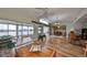 Open-concept living space featuring wood flooring, sliders to the lanai, and views of the waterfront backyard at 407 Blackhawk Cir, Sun City Center, FL 33573
