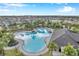 Aerial view of resort-style community pool with lounge chairs and cabana at 5493 Blue Azure Dr, Wimauma, FL 33598