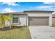 One-story house with attached garage and palm trees at 5493 Blue Azure Dr, Wimauma, FL 33598
