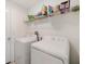 Bright laundry room with washer, dryer, and shelving at 5493 Blue Azure Dr, Wimauma, FL 33598