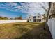 Spacious backyard featuring a large grass area and a white fence, perfect for outdoor activities and privacy at 5946 Bayou Grande Ne Blvd, St Petersburg, FL 33703