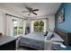 Comfortable bedroom featuring a fan, large window, exterior access, and accent wall at 5946 Bayou Grande Ne Blvd, St Petersburg, FL 33703