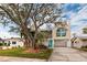 Charming two-story coastal home featuring a bright blue front door and lush landscaping in a beautiful waterfront community at 5946 Bayou Grande Ne Blvd, St Petersburg, FL 33703