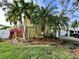 Charming coastal home featuring lush tropical landscaping, and bright blue front door in a beautiful waterfront community at 5946 Bayou Grande Ne Blvd, St Petersburg, FL 33703
