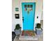 Inviting front entrance with a bright turquoise door, a charming welcome mat, and elegant planters in a cozy setting at 5946 Bayou Grande Ne Blvd, St Petersburg, FL 33703