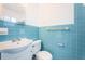 Bathroom with light blue tiled walls, vanity, and toilet at 601 Paris S Ave, St Petersburg, FL 33701