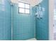 Bathroom with light blue tiled shower and window at 601 Paris S Ave, St Petersburg, FL 33701
