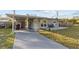 Front view of the house with a long driveway and green lawn at 1890 San Mateo Dr, Dunedin, FL 34698