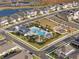 A bird's eye view showcases the community pool, playground, and surrounding homes nestled near a serene lake at 2391 Summerlit St, Lutz, FL 33558