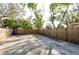 Backyard featuring a wooden fence, partial shade from mature trees, and a concrete pad at 3424 Queensboro S Ave, St Petersburg, FL 33711