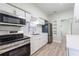Updated kitchen with stainless steel appliances, white cabinetry, modern countertops, and updated flooring at 3424 Queensboro S Ave, St Petersburg, FL 33711