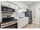 Updated kitchen with stainless steel appliances, white cabinetry, and modern countertops at 3424 Queensboro S Ave, St Petersburg, FL 33711