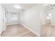 Bright living room featuring updated light gray vinyl flooring and fresh paint that leads into the kitchen at 3424 Queensboro S Ave, St Petersburg, FL 33711