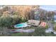 Overhead shot of a community clubhouse, pool, and playground near a lake at 3466 Maclaren Dr, Palm Harbor, FL 34684