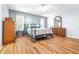 Main bedroom with wood-look floors, ceiling fan and ensuite bathroom at 3466 Maclaren Dr, Palm Harbor, FL 34684
