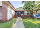 Inviting single-story home featuring a charming front entrance with a well-manicured lawn and lush landscaping at 3466 Maclaren Dr, Palm Harbor, FL 34684