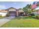 Inviting one-story home with attached garage, green lawn and flag at 3466 Maclaren Dr, Palm Harbor, FL 34684
