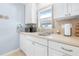 Kitchen with white cabinets, tile backsplash and stainless steel sink at 3466 Maclaren Dr, Palm Harbor, FL 34684