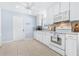 White kitchen features stainless steel appliances and light-colored tile floors at 3466 Maclaren Dr, Palm Harbor, FL 34684