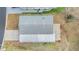 Aerial view of a home showing a gray roof, carport and landscaping at 37340 Neukom Ave, Zephyrhills, FL 33541
