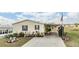 Cute yellow single-wide home with landscaped yard and American flag at 37340 Neukom Ave, Zephyrhills, FL 33541