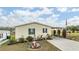 Well-maintained manufactured home with landscaped yard and carport at 37340 Neukom Ave, Zephyrhills, FL 33541