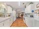 Bright kitchen with white cabinets and laminate flooring at 37340 Neukom Ave, Zephyrhills, FL 33541