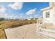 Spacious patio with stairs leading to a grassy yard and homes in the background at 37340 Neukom Ave, Zephyrhills, FL 33541